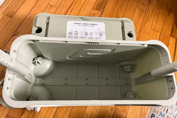 An opened ​​Stokke JetKids BedBox on a wooden floor
