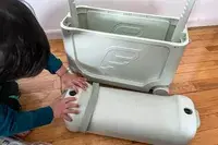 A child placing the lid of the ​​Stokke JetKids BedBox on the floor next to the box
