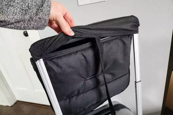 A hand touching the covered handle of the Mountain Buggy Skyrider Luxury