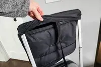 A hand touching the covered handle of the Mountain Buggy Skyrider Luxury