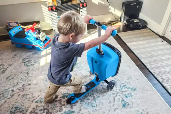 A child on the Micro Kickboard Micro Scooter Luggage Junior LED