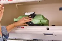 A person places the Ortlieb Velocity PS Pack 17L in an overhead compartment of an airplane