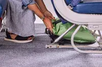 A person places the Ortlieb Velocity PS Pack 17L under an airplane seat