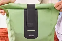 A person rolls and secures the top of the Ortlieb Velocity PS Pack 17L