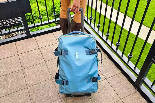 Cotopaxi Allpa 65L Roller Bag being pulled on a balcony