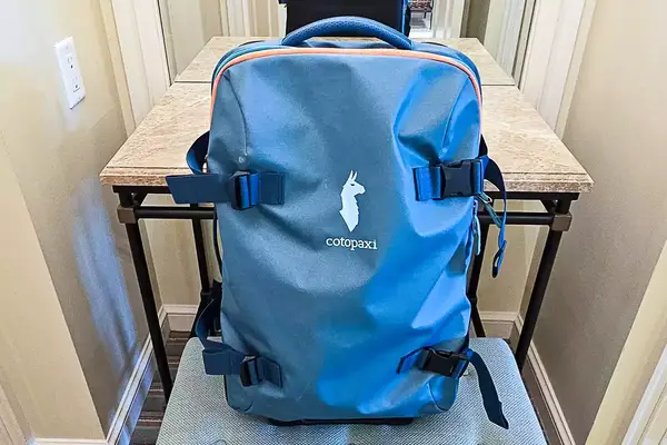 Cotopaxi Allpa 65L Roller Bag displayed on a small table