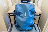 Cotopaxi Allpa 65L Roller Bag displayed on a small table