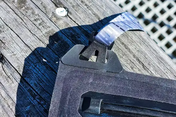 A close-up of the strap of the Nite Ize RunOff Waterproof Phone Case on wood