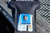 Cards in the Nite Ize RunOff Waterproof Phone Case resting on wood