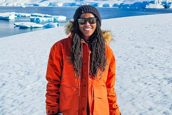 Woman stands in Antarctica near icebergs 