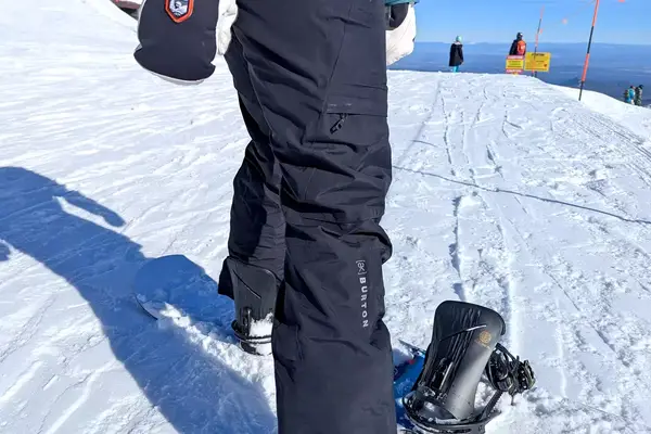 A close-up side-view of a person wearing the Burton Women’s AK Summit GORE-TEX 2L Pants on snow