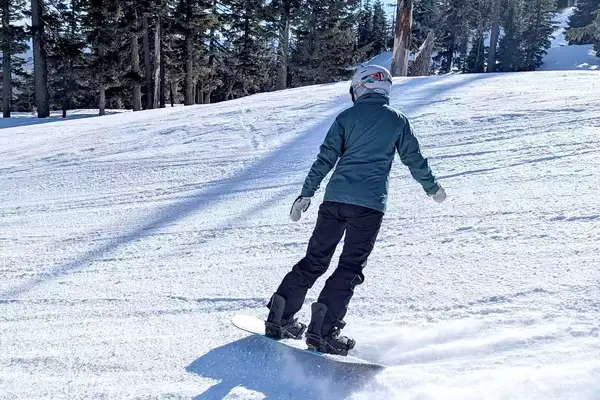 A person snowboarding while wearing the Burton Women’s AK Summit GORE-TEX 2L Pants