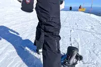 A close-up side-view of a person wearing the Burton Women’s AK Summit GORE-TEX 2L Pants on snow