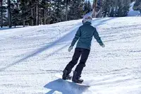 A person snowboarding while wearing the Burton Women’s AK Summit GORE-TEX 2L Pants