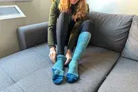 A person putting on the Fits Light Ski Sock