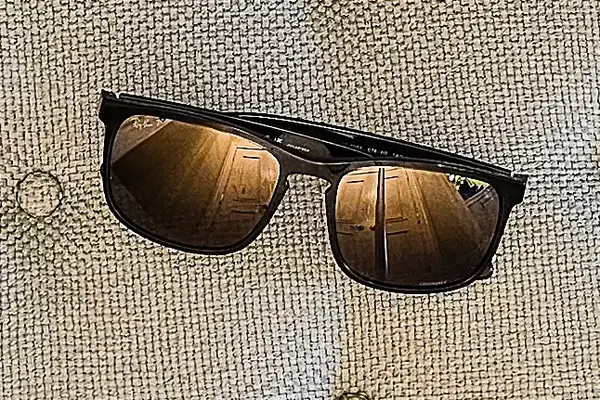 Ray-Ban Chromance Sunglasses resting on a textured surface, with reflections on the lenses