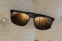 Ray-Ban Chromance Sunglasses resting on a textured surface, with reflections on the lenses
