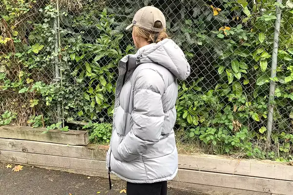A person wears the Quince Responsible Down Long Puffer Jacket