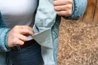 A person showing the inside pocket of the Outdoor Research Women