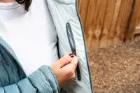 A hand holding the inside pocket of the Outdoor Research Women