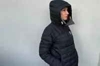 A person facing to the side while wearing the Fjallraven Expedition Pack Down Anorak