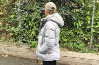 A person wears the Quince Responsible Down Long Puffer Jacket