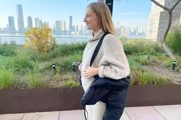 A person wearing the Canada Goose Garnet Cropped Puffer jacket by its straps