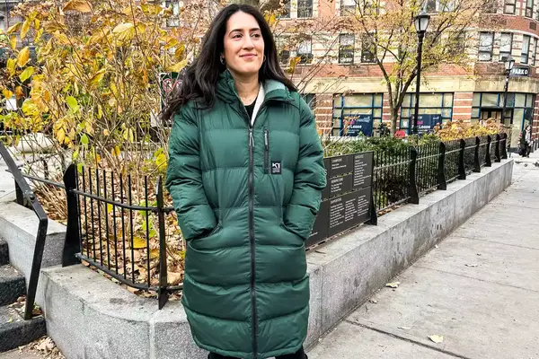 A person wears a Kari Traa Rongve Parka in a city park