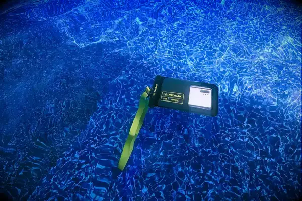 A phone in the Case-Mate Pelican Marine IP68 Waterproof Phone Pouch submerged in a pool