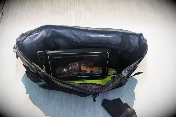 The Case-Mate Pelican Marine IP68 Waterproof Phone Pouch in a bag resting on concrete