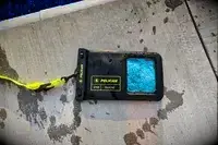A wet Case-Mate Pelican Marine IP68 Waterproof Phone Pouch on concrete