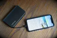 The myCharge Fast Charging Portable Charger charging a phone on a wooden surface