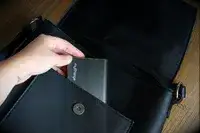 A hand placing the myCharge Fast Charging Portable Charger into a bag