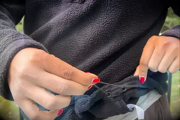 Person tightening the bottom of a Wild Rye Danner High-Pile Fleece Pullover