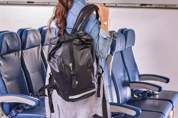 A person wears the Earth Pak Summit Dry Bag Backpack
