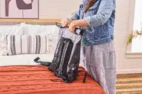 A person rolls up the Earth Pak Summit Dry Bag Backpack