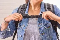 A person tightens the strap on the Earth Pak Summit Dry Bag Backpack