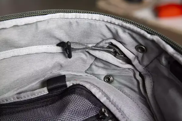 A person adjusts the waist strap on the Cotopaxi Allpa 42L Travel Pack