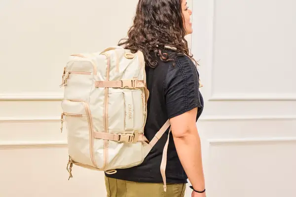 A person wears the Calpak Terra 26L Laptop Duffel Backpack