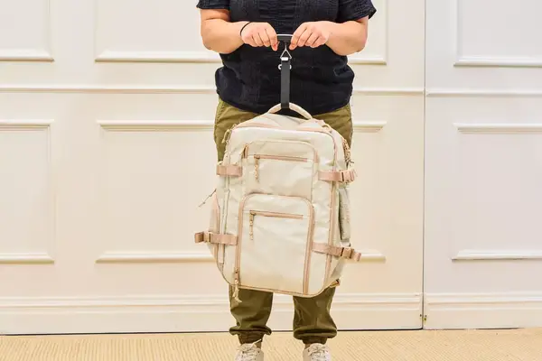 A person weighs the Calpak Terra 26L Laptop Duffel Backpack