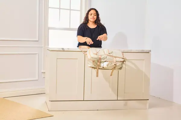 A person throws the Calpak Terra 26L Laptop Duffel Backpack from a table