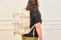 A person wears the Calpak Terra 26L Laptop Duffel Backpack