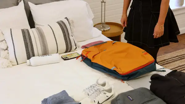 A person prepares to pack the Cotopaxi Allpa 42L Travel Pack