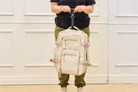 A person weighs the Calpak Terra 26L Laptop Duffel Backpack