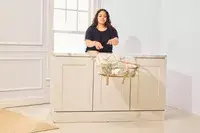 A person throws the Calpak Terra 26L Laptop Duffel Backpack from a table