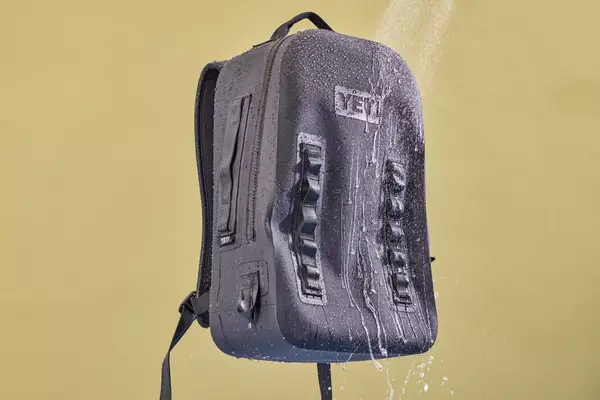 Water is sprayed on the Yeti Panga 28L Waterproof Backpack