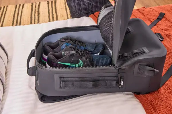 Shoes are placed inside the Yeti Panga 28L Waterproof Backpack