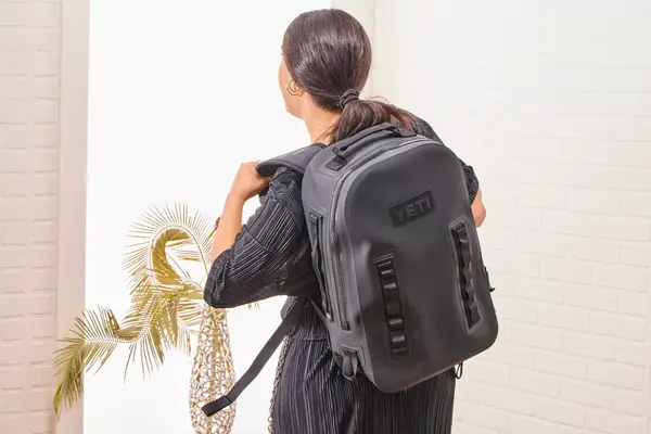 A person wears the Yeti Panga 28L Waterproof Backpack