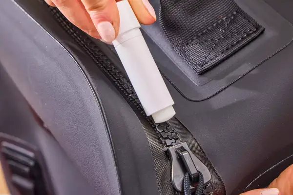 A person uses the Yeti Zipper Lubricant on the Yeti Panga 28L Waterproof Backpack