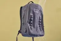Water is sprayed on the Yeti Panga 28L Waterproof Backpack